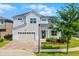 Two-story home with brick driveway, a two-car garage, and solar panels on the roof at 1909 Donahue Dr, Ocoee, FL 34761