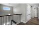Second floor hallway with wood floors and natural light from the window above the stairs at 1909 Donahue Dr, Ocoee, FL 34761