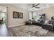 Cozy living room featuring a sectional sofa, ceiling fan, plantation shutters, and hardwood floors at 1909 Donahue Dr, Ocoee, FL 34761