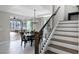 A wood and white staircase with a view into the dining room and sliding glass doors at 1909 Donahue Dr, Ocoee, FL 34761