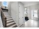 A stairway with a stained wood handrail leading to the second floor and view of the foyer and front door at 1909 Donahue Dr, Ocoee, FL 34761