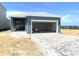 A charming one-story home featuring a gray-blue facade, paved driveway, and attached garage at 1912 Diamond Head Cir, Lake Hamilton, FL 33851