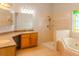 Bright bathroom featuring double vanity, glass enclosed shower, and soaking tub with stained glass window at 1949 Tiptree Cir, Orlando, FL 32837