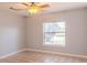 This bedroom is bright and features a neutral color scheme, tile flooring, a ceiling fan, and a window with a pond view at 1949 Tiptree Cir, Orlando, FL 32837