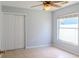 Neutral bedroom showcases tile flooring, a ceiling fan, and a large window, enhanced by a spacious closet at 1949 Tiptree Cir, Orlando, FL 32837