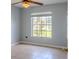 Well-lit bedroom showcases a large window, neutral color palette, and tile flooring, creating a simple and serene atmosphere at 1949 Tiptree Cir, Orlando, FL 32837