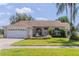 Charming single-story home features a manicured lawn, inviting fountain, and attached two car garage at 1949 Tiptree Cir, Orlando, FL 32837