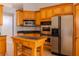Well-lit kitchen with wood cabinets, stainless appliances, an island and tile flooring at 1949 Tiptree Cir, Orlando, FL 32837