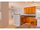 Open kitchen with tile floor, wood cabinets, peninsula and views into the living area at 1949 Tiptree Cir, Orlando, FL 32837