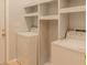 Clean laundry room features washer, dryer, and built-in shelving for storage at 1949 Tiptree Cir, Orlando, FL 32837