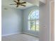 Open living space with neutral paint, tile flooring, arched window, and ceiling fan at 1949 Tiptree Cir, Orlando, FL 32837