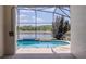 View of the pool through the screen showing the waterfront view behind the house at 1949 Tiptree Cir, Orlando, FL 32837