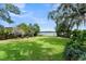 Expansive backyard with lush green lawn, mature trees, and serene lake view, ideal for outdoor enjoyment at 195 E Faith Ter, Maitland, FL 32751