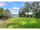 Spacious backyard with mature trees, outdoor seating, and picturesque lake views at 195 E Faith Ter, Maitland, FL 32751