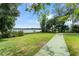 Lush backyard with a shuffleboard court, green lawn, and tranquil lake views at 195 E Faith Ter, Maitland, FL 32751