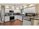 Bright kitchen featuring white cabinets, stainless steel appliances, and wood flooring at 195 E Faith Ter, Maitland, FL 32751