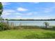 Scenic lake view with lush green lawn, water vegetation, and a beautiful blue sky at 195 E Faith Ter, Maitland, FL 32751