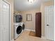 Bright laundry room featuring a front-load washer and dryer, tile flooring and storage at 195 E Faith Ter, Maitland, FL 32751