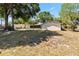 Wide backyard featuring grass, sandy patches and a view of a neighboring home and backyard at 2007 Peach Tree Blvd, St Cloud, FL 34769