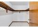 Walk-in closet boasts wooden shelves and ample storage space with white walls and neutral carpeting at 2007 Peach Tree Blvd, St Cloud, FL 34769