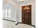 Bright foyer featuring white tile flooring, arched doorways, and a dark wooden door at 2007 Peach Tree Blvd, St Cloud, FL 34769