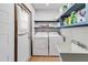 Well-lit laundry room featuring a washing machine, dryer, shelving, and a utility sink at 2007 Peach Tree Blvd, St Cloud, FL 34769