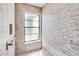 Modern shower with beige textured tile, safety bars, frosted window, and built-in bench at 2007 Peach Tree Blvd, St Cloud, FL 34769