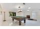 Spacious game room features a pool table, marble floors, modern lighting, and a large window at 2108 Silver Leaf Ct, Longwood, FL 32779