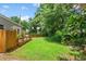 Expansive backyard showcasing a well-maintained lawn, a wooden deck, and lush greenery at 2707 E Marks St, Orlando, FL 32803