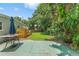 Serene backyard featuring lush tropical foliage, a green lawn, and a shaded patio area at 2707 E Marks St, Orlando, FL 32803