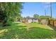 Wide shot of the spacious backyard, deck, and house under a blue sky at 2707 E Marks St, Orlando, FL 32803