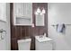 Compact bathroom features dark wood-look tiling, vanity with sink, toilet, and medicine cabinet at 2707 E Marks St, Orlando, FL 32803