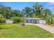 Attractive single-story home with a lush green lawn, complemented by mature trees and tropical landscaping at 2707 E Marks St, Orlando, FL 32803