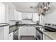Efficient kitchen with white cabinets, stainless steel appliances, and ample counter space at 2707 E Marks St, Orlando, FL 32803