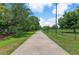 Scenic walking path lined with green grass and trees on a sunny day at 2707 E Marks St, Orlando, FL 32803