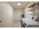 This laundry room features tile flooring, wire shelving, modern washer and dryer, and a door to the outside at 2711 Parkland Dr, Winter Park, FL 32789