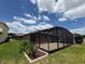 View of backyard and patio with full view of screened enclosure at 274 Brunswick Dr, Davenport, FL 33837