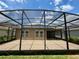 Backyard with covered lanai and large screened in patio and views of neighboring houses at 274 Brunswick Dr, Davenport, FL 33837