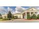 Elegant clubhouse with covered entrance, landscaped grounds and lush shrubs and trees under a blue sky at 274 Brunswick Dr, Davenport, FL 33837