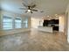 Bright living room featuring tile floors, ceiling fan, and natural light from the large windows at 274 Brunswick Dr, Davenport, FL 33837