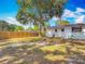 Large backyard featuring a mature tree, a wood fence, and the home's white exterior at 288 N Seneca St, Daytona Beach, FL 32114