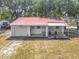 Charming single-story home featuring a red metal roof, a front porch and an attached garage at 288 N Seneca St, Daytona Beach, FL 32114