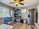 A living room featuring a refrigerator, shelving, and a ceiling fan with laminate flooring at 288 N Seneca St, Daytona Beach, FL 32114