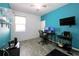 Bright bedroom with wood-look floors, ceiling fan, desk, and blue accent wall, perfect for a home office at 2952 Boating Blvd, Kissimmee, FL 34746