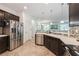 Stainless steel refrigerator and dishwasher in kitchen with tile floors and dark wood cabinets at 2952 Boating Blvd, Kissimmee, FL 34746