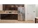 Kitchen featuring a stainless steel refrigerator and dark wood cabinets, complimented with a tiled backsplash at 2952 Boating Blvd, Kissimmee, FL 34746