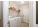 Functional laundry room with tile flooring, washer, dryer, storage shelf, and a convenient entry door at 2952 Boating Blvd, Kissimmee, FL 34746