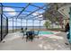 Inviting screened pool area with outdoor dining set and views of the serene waterfront at 3385 Lake Harney Cir, Geneva, FL 32732