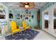 Cozy sunroom features vaulted ceiling, two yellow Adirondack chairs, and coastal decor at 3385 Lake Harney Cir, Geneva, FL 32732