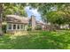 Large backyard with a lush lawn, mature trees, covered patio, and beautiful landscaping at 343 Raleigh Pl, Oviedo, FL 32765